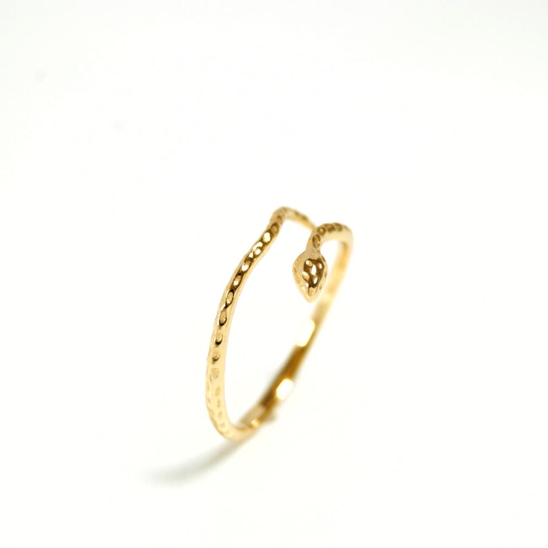 May include: A gold snake ring with a textured finish. The snake is curled into a circle and the head is facing forward.
