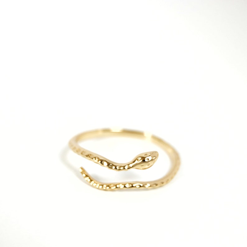 May include: A gold snake ring with a textured finish. The snake is curled around the ring band.