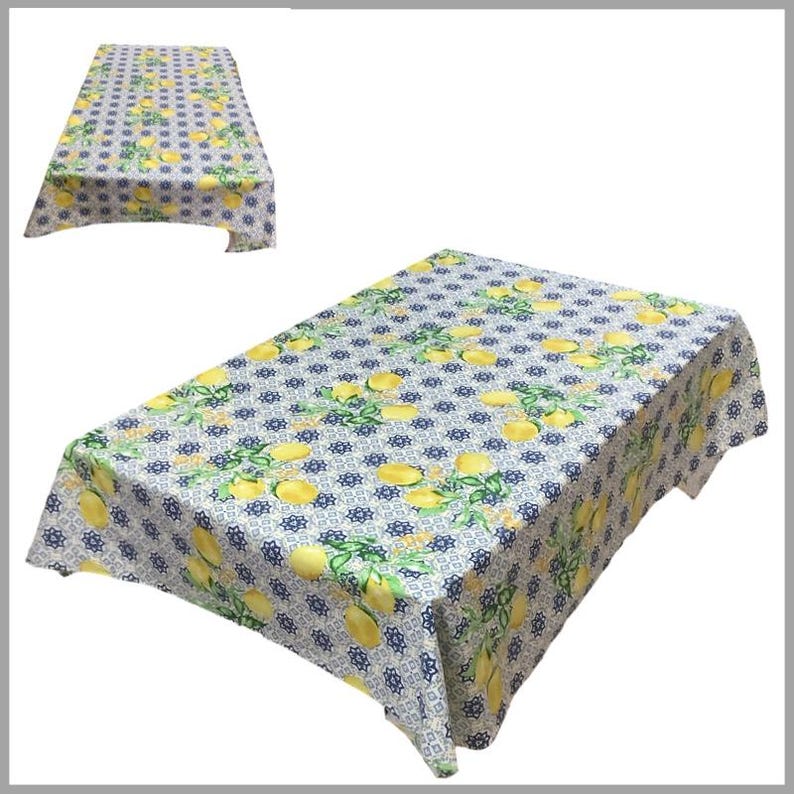 May include: White tablecloth with a lemon and blue tile pattern. The tablecloth is rectangular and has a scalloped edge.