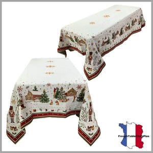 May include: Two white Christmas tablecloths with a festive design. The tablecloths feature a repeating pattern of winter scenes, including houses, trees, and nutcrackers, with a red border. The overall theme is holiday decor.
