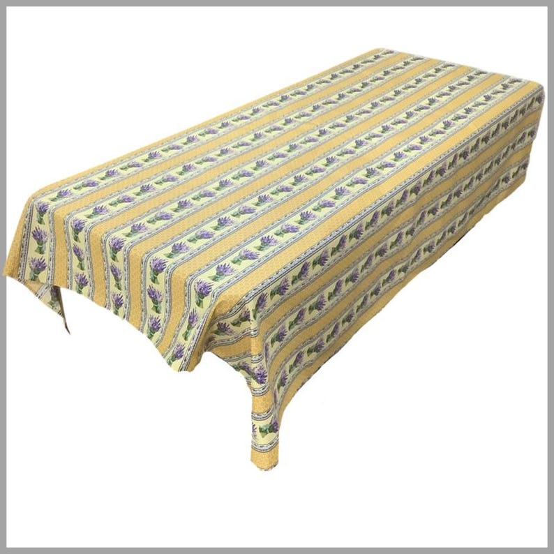 May include: A yellow and white striped tablecloth with a lavender floral pattern. The tablecloth is made of cotton and is perfect for a farmhouse or country style table setting.