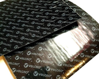 May include: Two black sheets of hook and loop fastener, also known as Velcro, with the brand name printed on the surface.