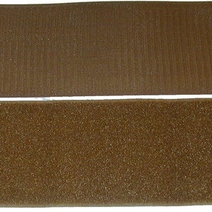 May include: Two pieces of brown hook and loop fastener, also known as Velcro. The top piece is the hook side, and the bottom piece is the loop side.