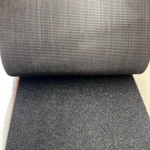 May include: Close-up of black elastic fabric with a textured weave. The fabric is rolled up, showing the inside and outside of the material.