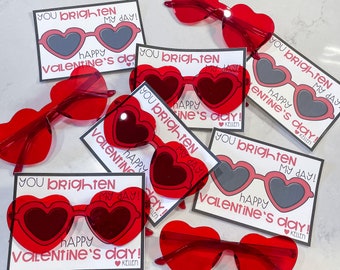 May include: A set of ten Valentine's Day cards featuring heart-shaped sunglasses and the text "You brighten my day! Happy Valentine's Day!"