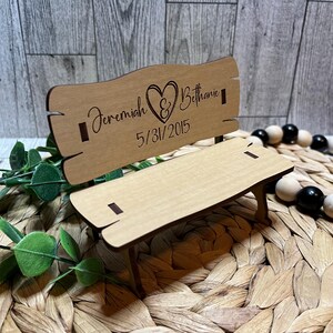 Puede incluir: Un banco de madera con un coraz&oacute;n y los nombres Jeremiah & Bethanie y la fecha 5/31/2015 grabados en la parte posterior.