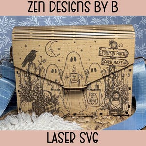 May include: A rectangular wooden bag with a laser-engraved Halloween scene featuring three ghosts, a crow, a crescent moon, a pumpkin patch sign, and a lantern. The bag has a light blue strap and the text ZEN DESIGNS BY B and LASER SVG.