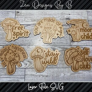 May include: Six wooden laser cut mushroom designs with different phrases. The phrases are "free spirit", "you are made of magic", "moon child", "radiate happiness", "stay wild", and "self love club".