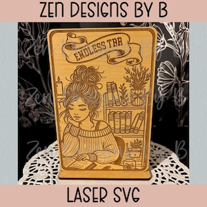 Könnte beinhalten: Hellbrauner, lasergeschnittener Buchständer aus Holz. Das Design zeigt eine lesende Person, ein Bücherregal und den Text "ENDLESS TBR" auf einem Banner. Der Ständer hat einen dekorativen Sockel. Der Text "LASER SVG" befindet sich unten.