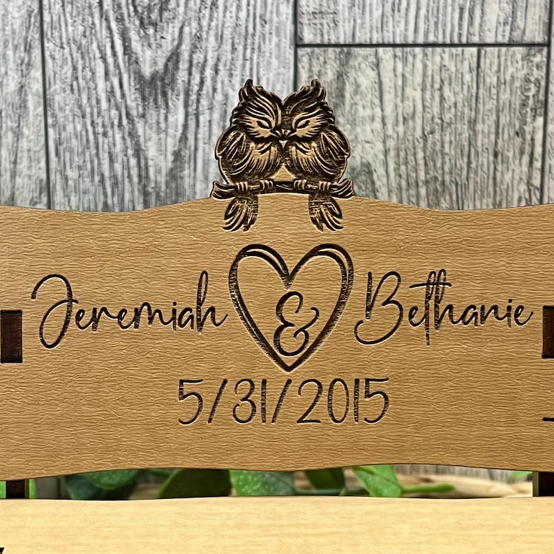 Puede incluir: Un respaldo de silla de boda de madera con una pareja de b&uacute;hos tallados, un coraz&oacute;n con una ampersand, los nombres Jeremiah & Bethanie y la fecha 5/31/2015.