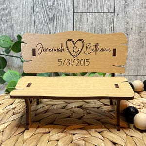 Puede incluir: Un peque&ntilde;o banco de madera con un coraz&oacute;n y los nombres Jeremiah & Bethanie y la fecha 5/31/2015 grabados en el respaldo.