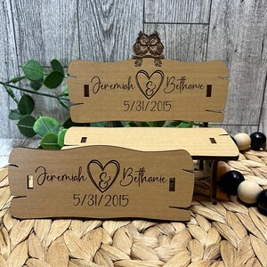 Puede incluir: Un banco de madera con un coraz&oacute;n y los nombres Jeremiah y Bethanie, y la fecha 5/31/2015 grabada en &eacute;l. Dos b&uacute;hos est&aacute;n posados en la parte superior del banco.