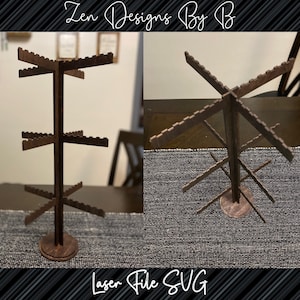 May include: A brown wooden display stand with multiple tiers, perfect for showcasing jewelry or small items. The stand has a circular base and a series of horizontal arms. The text "Zen Designs By B" and "Laser File SVG" are visible.