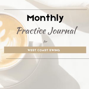 May include: A white journal cover featuring the text Monthly Practice Journal for WEST COAST SWING in black and tan lettering. To the left, a partial view of a white ceramic cup filled with a latte showing latte art is visible.