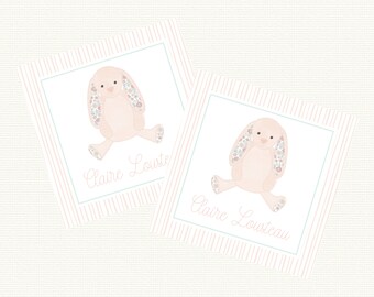 May include: Two pink and white personalized bunny rabbit gift tags with pink and white striped backgrounds. The tags feature the name "Claire Lousteau" in a cursive font.