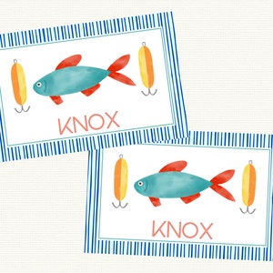 May include: Two blue and red fish with yellow and orange fishing lures on a white background with blue and white stripes. The name "KNOX" is printed below each fish.