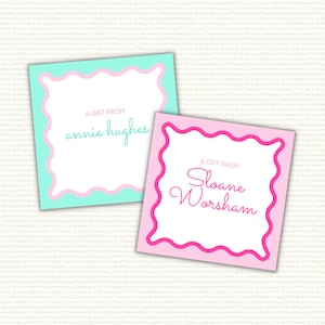 May include: Two gift tags with scalloped edges. The top tag is light blue with a pink border and says "A gift from annie hughes". The bottom tag is pink with a hot pink border and says "A gift from Sloane Worsham".