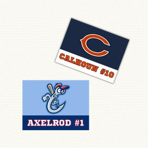 May include: Two baseball team name cards. The top card is navy blue with a white outline and a large orange letter C. The text "CALHOUN #10" is printed in white. The bottom card is light blue with a cartoon illustration of a hook with a baseball bat and a red baseball cap. The text "AXELROD #1" is printed in white.