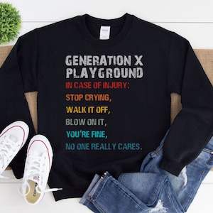 May include: Black sweatshirt with a vintage-style graphic that reads "Generation X Playground" and includes the text "In case of injury: Stop crying, Walk it off, Blow on it, You're fine, No one really cares."