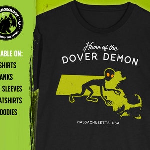 May include: Black t-shirt with a green outline of the state of Massachusetts and a gray alien creature with orange eyes. The text "Home of the Dover Demon" and "Massachusetts, USA" are printed on the shirt.