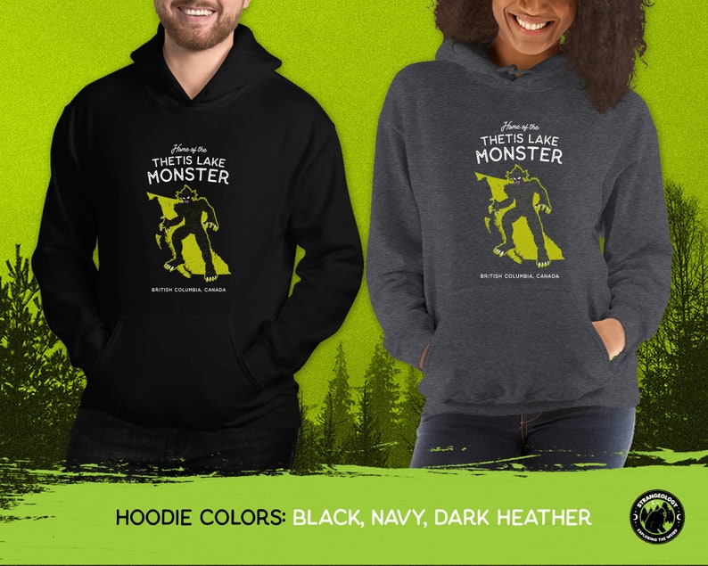 K&ouml;nnte beinhalten: Schwarze, marineblaue und dunkelgraue Kapuzenpullover mit einem Monster-Motiv in Form von British Columbia, Kanada. Der Text "Home of the Thetis Lake Monster" ist auf dem Pullover aufgedruckt.