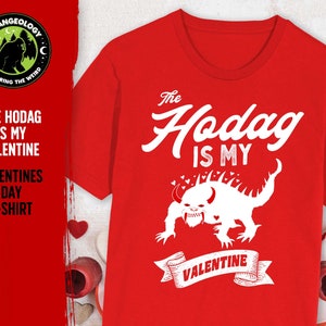 May include: Red t-shirt featuring a white graphic of a mythical creature known as a Hodag. The text "The Hodag is my Valentine" is printed on the shirt.