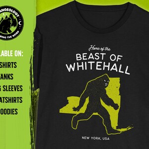 May include: Black t-shirt with a yellow graphic of a Bigfoot-like creature walking across a yellow outline of the state of New York. The text "Home of the BEAST OF WHITEHALL" is above the graphic and "NEW YORK, USA" is below. The text "AVAILABLE ON: T-SHIRTS, TANKS, LONG SLEEVES, SWEATSHIRTS & HOODIES" is on the left side of the image.