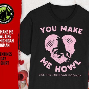 May include: Black t-shirt with a pink heart and a wolf silhouette. The text "You make me howl like the Michigan Dogman" is printed on the shirt.