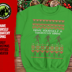 May include: Green Christmas jumper with a festive design featuring a repeating pattern of brown trees and a white inscription that reads "Have Yourself a Squatchy Xmas". Three brown Bigfoot figures are walking across the jumper.