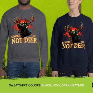 Pu&ograve; includere: Due felpe con una grafica di un cervo con occhi rossi luminosi e il testo "Beware the Not Deer". Le felpe sono disponibili in nero, blu navy e grigio scuro.