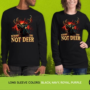 Pu&ograve; includere: Maglietta a maniche lunghe nera con una grafica di un cervo con occhi rossi luminosi e il testo "Beware the Not Deer".