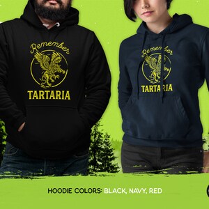 Peut inclure: Sweat-shirts noirs, bleus marine et rouges avec un graphique de griffon et le texte "Remember Tartaria".