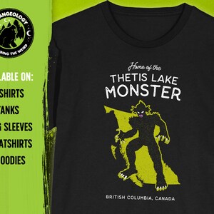 K&ouml;nnte beinhalten: Schwarzes T-Shirt mit einer gelben Grafik eines Monsters vor dem Umriss von British Columbia. Der Text "Home of the Thetis Lake Monster" befindet sich &uuml;ber der Grafik und "British Columbia, Canada" unter der Grafik.
