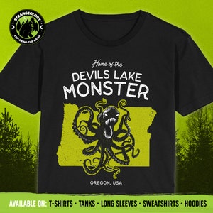 May include: Black t-shirt featuring a yellow outline of the state of Oregon and a black octopus with a menacing expression. The text "Home of the Devils Lake Monster" and "Oregon, USA" are printed on the shirt.