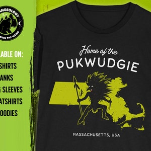 May include: Black t-shirt with a yellow outline of the state of Massachusetts and a cartoon illustration of a creature called the Pukwudgie. The text "Home of the PUKWUDGIE" and "MASSACHUSETTS, USA" are printed on the shirt.