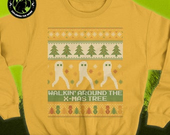 May include: A yellow Christmas sweater with a green and white pixelated design of ghosts walking around a Christmas tree. The text "WALKIN' AROUND THE X-MAS TREE" is printed on the sweater. The sweater is part of the Fresno Nightcrawlers Ugly Christmas Cryptid Sweater collection.