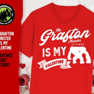 May include: Red t-shirt with a white graphic that says "The Grafton Monster is My Valentine" with a cartoon monster illustration.