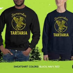 Peut inclure: Sweat-shirts noirs et bleu marine avec un motif jaune d'un griffon avec le texte "Remember Tartaria".