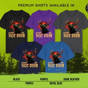 Pu&ograve; includere: Cinque t-shirt di diversi colori con una grafica di un cervo con il testo "Beware the Not Deer". I colori sono nero, viola, grigio scuro, blu reale e viola.