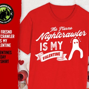 May include: Red t-shirt with a white graphic that says "The Fresno Nightcrawler is my Valentine" with a cartoon ghost and hearts.