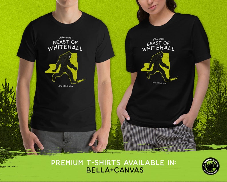 May include: Two black t-shirts with a yellow graphic of a Bigfoot-like creature walking across a silhouette of New York State. The text "Home of the Beast of Whitehall" is printed above the graphic. The text "New York, USA" is printed below the graphic.