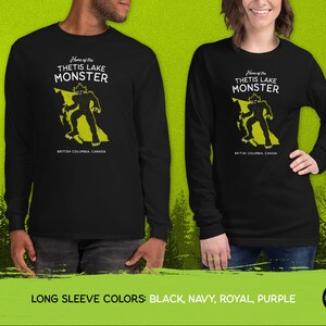 K&ouml;nnte beinhalten: Schwarzes Langarmshirt mit einer gelben Grafik eines Monsters in Form von British Columbia, Kanada. Der Text "Home of the Thetis Lake Monster" ist auf dem Shirt aufgedruckt.