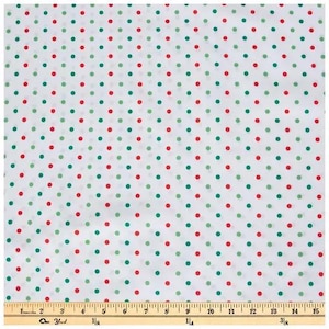 May include: A white fabric featuring a repeating pattern of small red and green polka dots arranged in vertical columns. A wooden ruler is positioned at the bottom edge, showing measurements in inches up to 15 inches for scale.