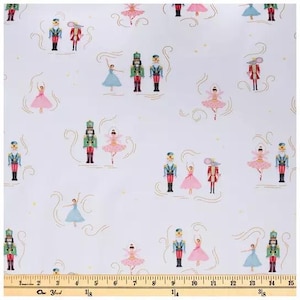 May include: White fabric featuring a repeating pattern of nutcracker soldiers, ballerinas in pink and blue dresses, and mouse characters in red uniforms. A yellow measuring tape is visible at the bottom, showing a width of 15 inches.
