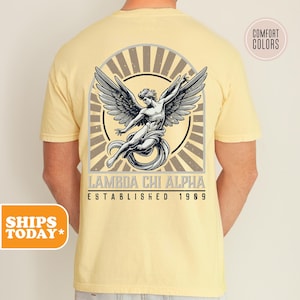 May include: A yellow t-shirt with a vintage-style graphic of an angel with wings spread. The graphic includes the text "Lambda Chi Alpha Established 1909".