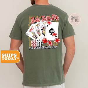 May include: A green t-shirt with a design featuring playing cards, dice, and the text "Beta Theta Pi" and "The House Always Wins".