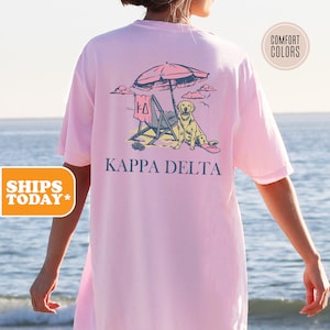 a woman wearing a pink shirt with a picture of a dog under an umbrella
