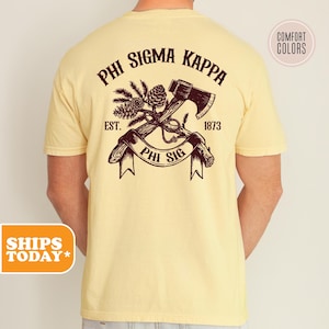 May include: A yellow t-shirt with a brown graphic of an axe and pine branches. The graphic includes the text "Phi Sigma Kappa", "Est. 1873", and "Phi Sig".