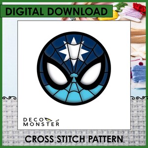 May include: A digital download cross stitch pattern featuring a circular graphic of a masked character face in shades of dark blue and light blue with a white star emblem on the forehead and large white eyes. The text reads DECO MONSTER.