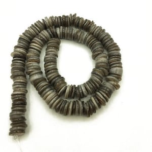 May include: A strand of gray and brown shell beads, each bead is a flat disc with a slightly raised center.